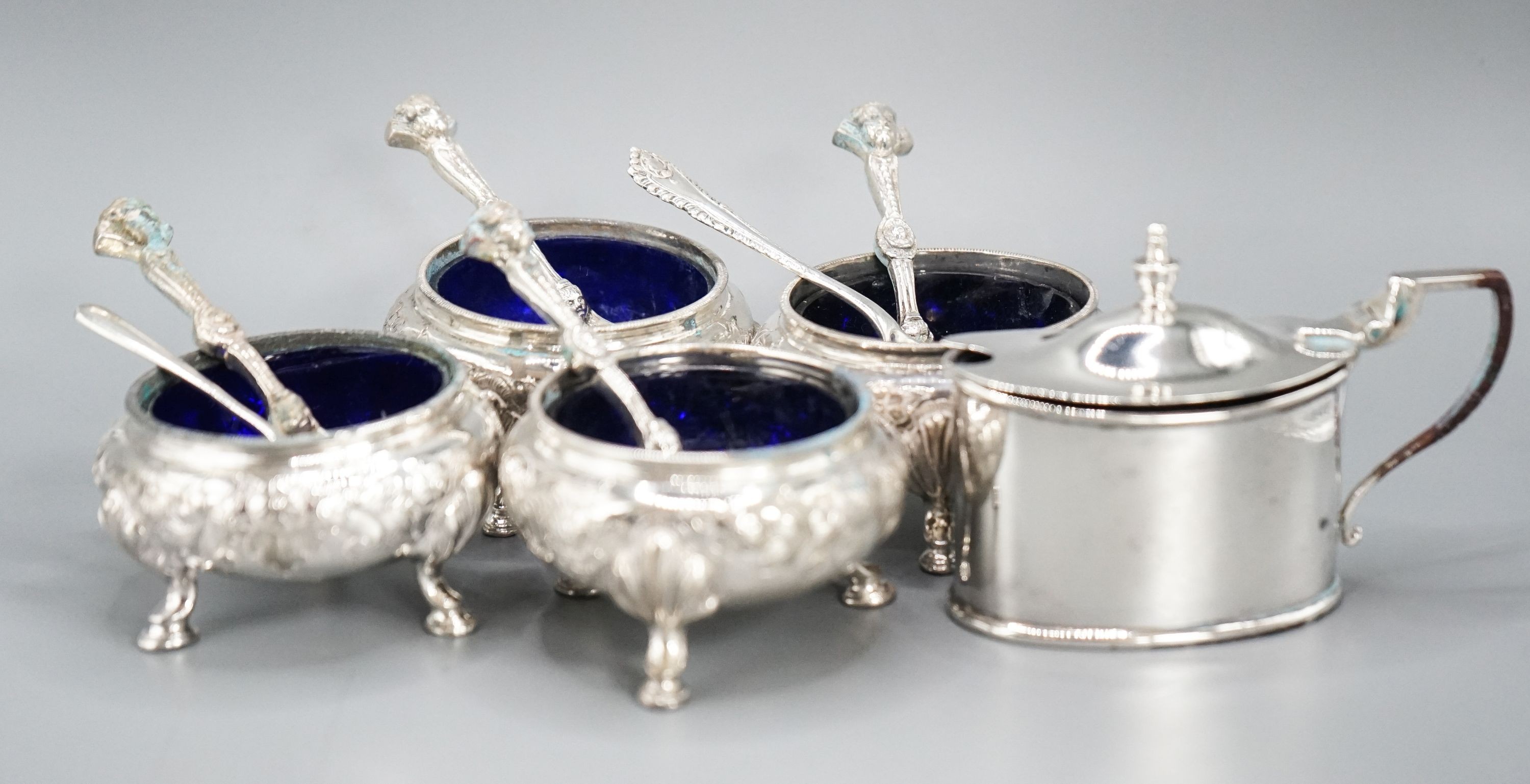 A set of four Victorian silver bun salts, Sheffield, 1869 and four associated silver spoons and a later silver mustard pot and two spoons.